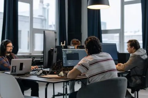 Team of developers working together on computers representing internal developer platforms