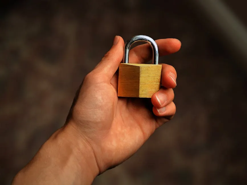 Hand holding a brass padlock, symbolizing security and protection — Photo by Nathan Thomas on Pexels