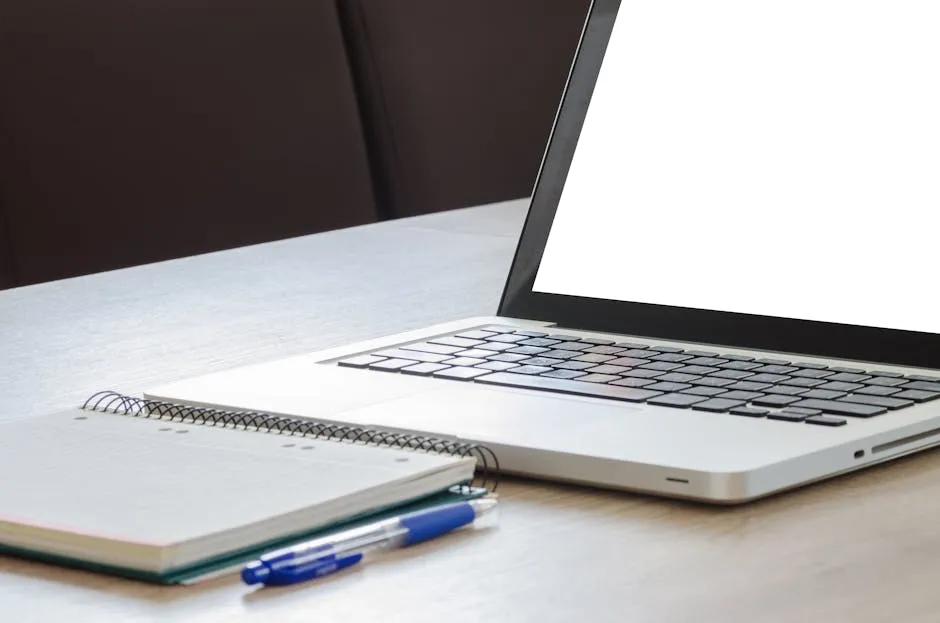 Open laptop with blank screen, notebook, and pen on a wooden desk, ideal for work or study. — Photo by Lukas Blazek on Pexels